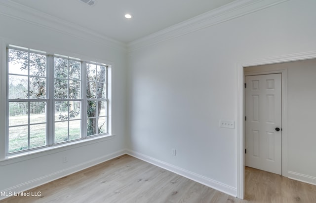 unfurnished room with light wood-type flooring, a healthy amount of sunlight, and crown molding