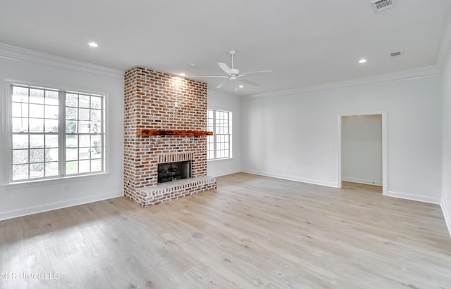 unfurnished living room with ceiling fan, light wood-type flooring, a brick fireplace, and crown molding