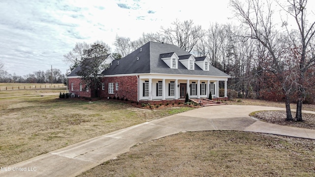 cape cod home with a porch and a front lawn