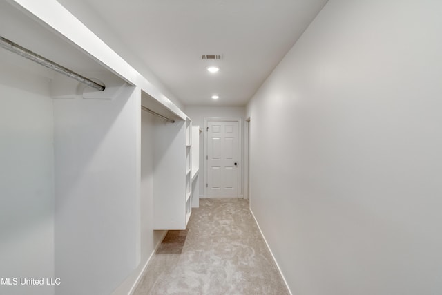 spacious closet featuring light colored carpet