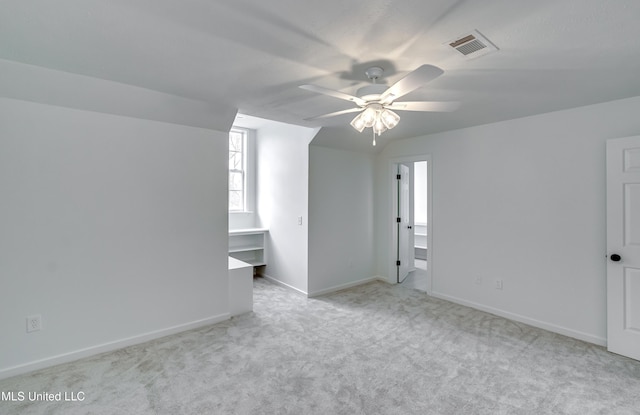 bonus room featuring ceiling fan and light carpet