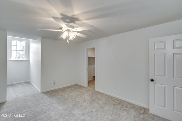 empty room featuring ceiling fan and light carpet