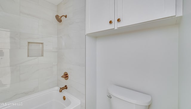 bathroom featuring toilet and tiled shower / bath