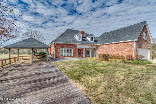 view of front of home featuring a garage, a front lawn, and a gazebo