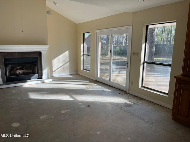 unfurnished living room featuring lofted ceiling and a tiled fireplace