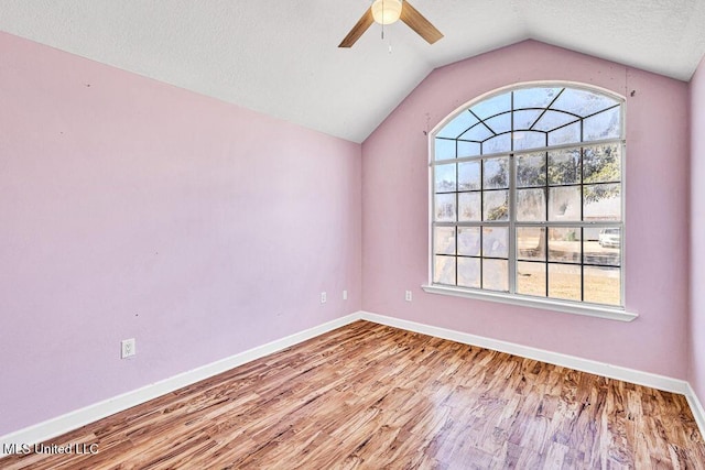 spare room with lofted ceiling, plenty of natural light, light hardwood / wood-style floors, and ceiling fan