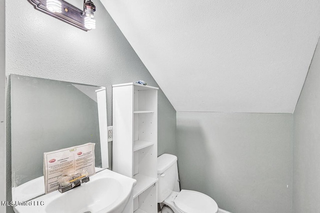 bathroom featuring vaulted ceiling, sink, and toilet