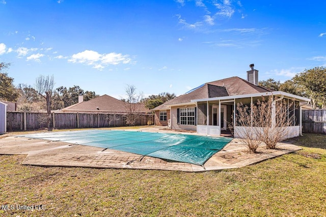 view of pool with a lawn, a sunroom, and a patio