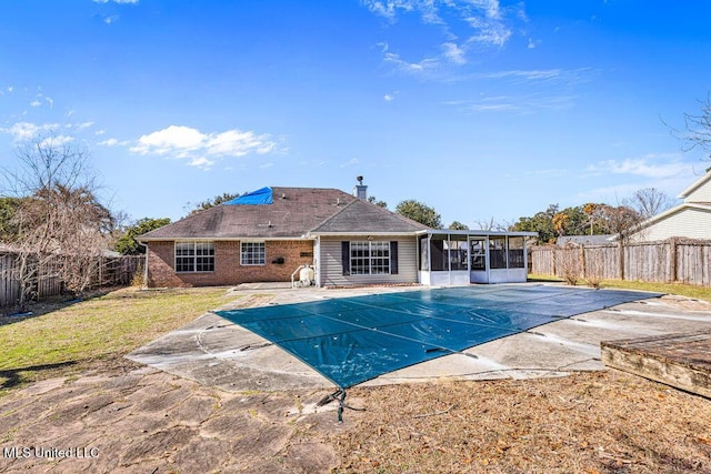 view of swimming pool with a sunroom and a patio area