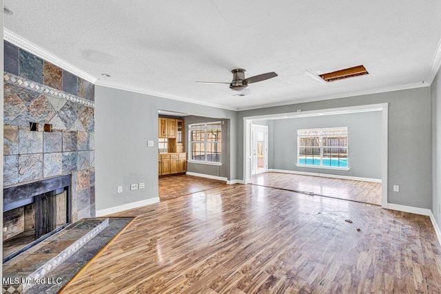 unfurnished living room featuring crown molding, a wealth of natural light, and hardwood / wood-style flooring