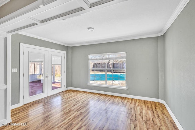 empty room featuring french doors, crown molding, and light hardwood / wood-style flooring