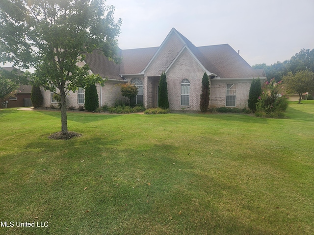 view of front of home featuring a front yard and brick siding