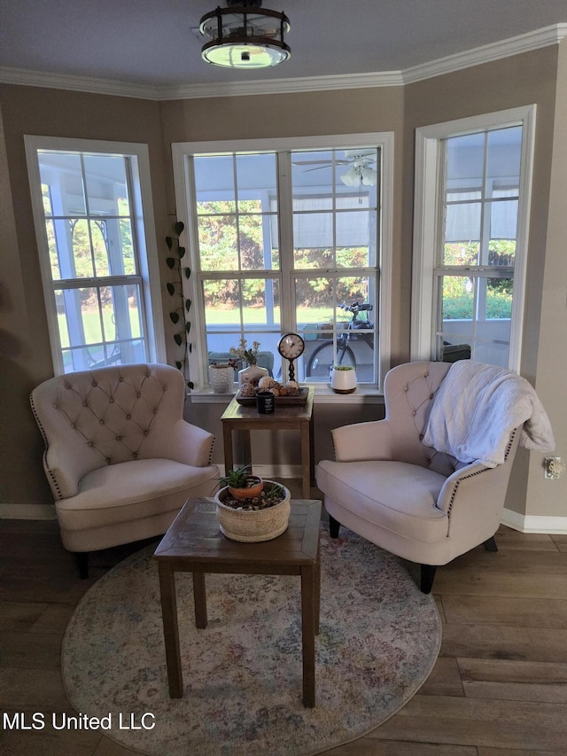 living room with crown molding, wood finished floors, a healthy amount of sunlight, and baseboards