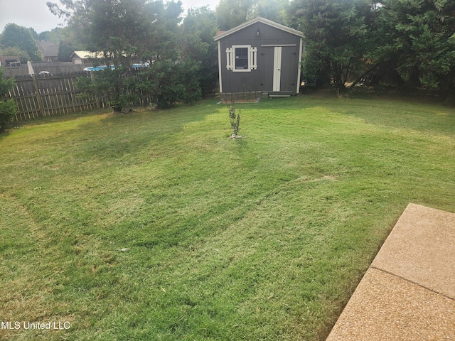 view of yard with a storage shed, an outbuilding, and fence