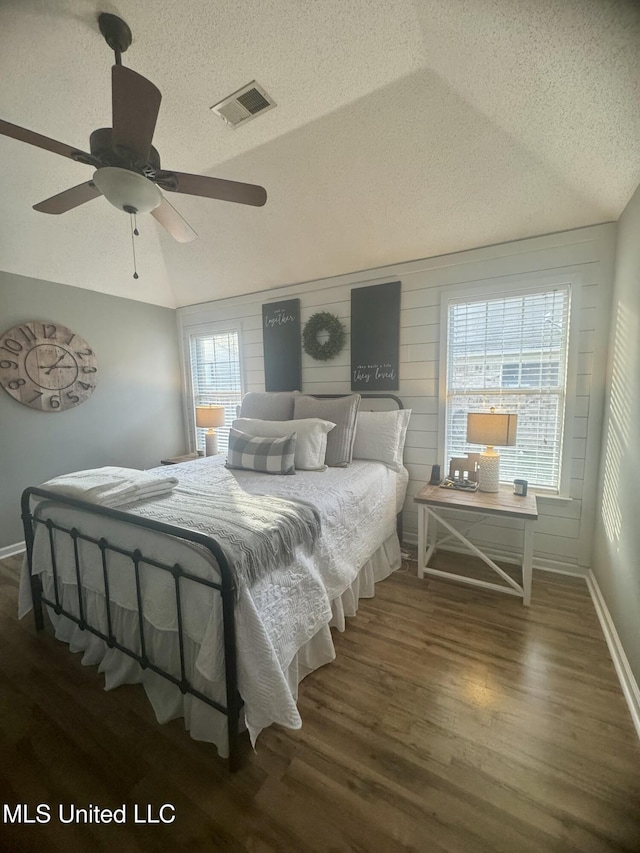 bedroom featuring wood finished floors, a textured ceiling, ceiling fan, and visible vents