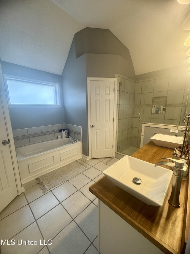 bathroom featuring lofted ceiling, tile patterned flooring, a sink, and a bath