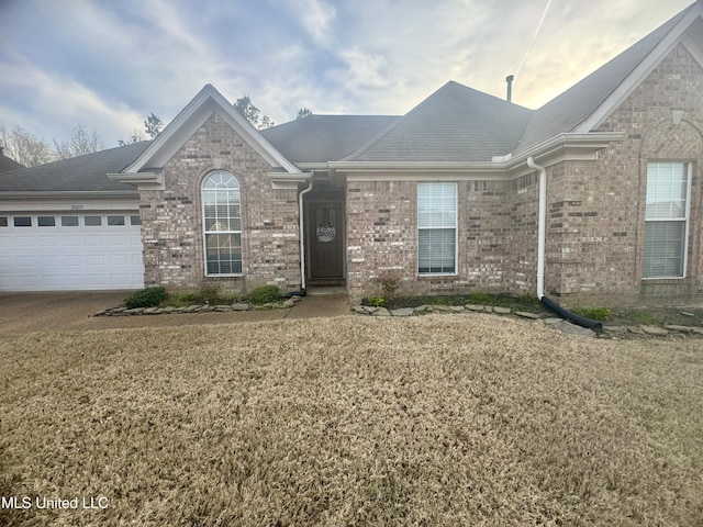 single story home featuring an attached garage, concrete driveway, and brick siding