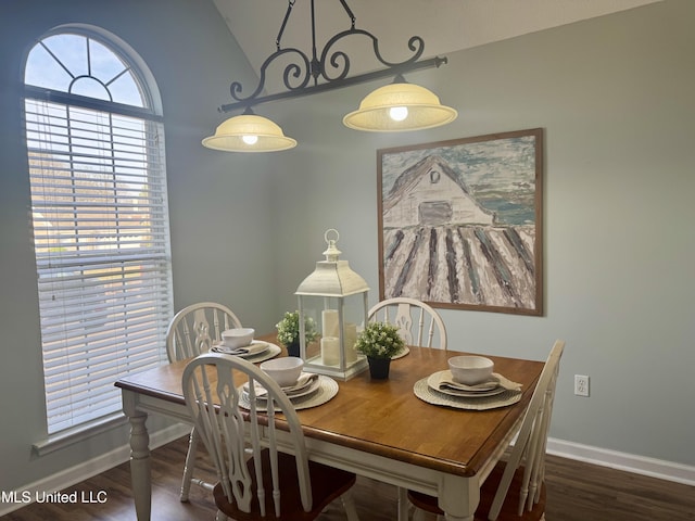 dining area featuring baseboards, wood finished floors, and vaulted ceiling
