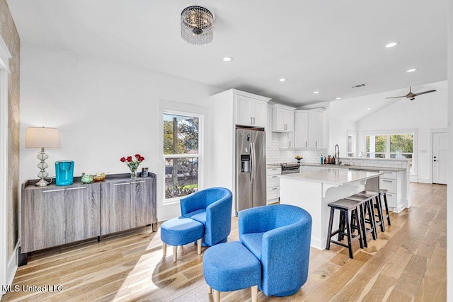 kitchen featuring sink, white cabinetry, stainless steel appliances, tasteful backsplash, and light hardwood / wood-style floors