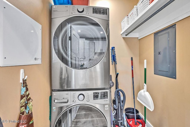 laundry area with stacked washer and dryer and electric panel