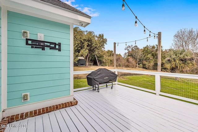 wooden terrace with area for grilling and a yard