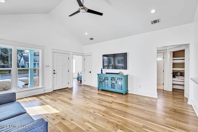 living room with high vaulted ceiling, ceiling fan, and light wood-type flooring