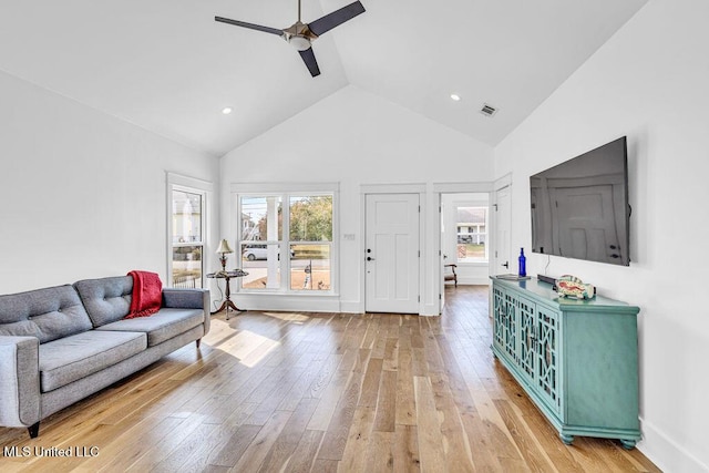 living room featuring hardwood / wood-style flooring, high vaulted ceiling, and ceiling fan