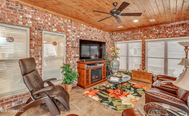 living room featuring light tile patterned floors, ceiling fan, wooden ceiling, and brick wall