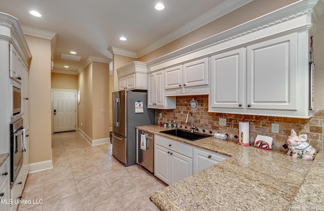 kitchen with decorative backsplash, sink, white cabinets, and stainless steel appliances