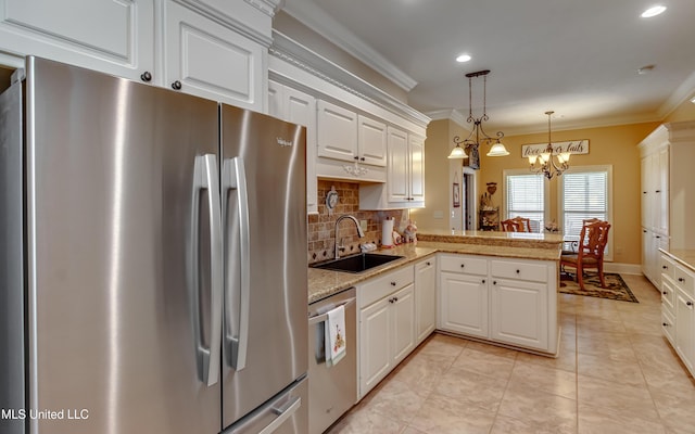 kitchen featuring sink, kitchen peninsula, a chandelier, decorative light fixtures, and appliances with stainless steel finishes