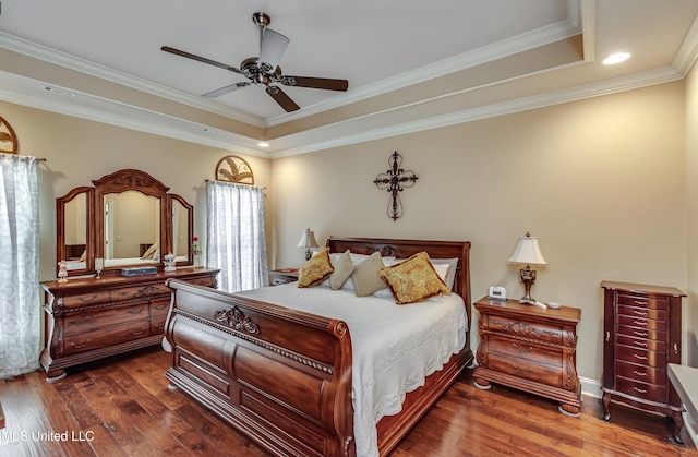 bedroom with ceiling fan, dark hardwood / wood-style flooring, ornamental molding, and a tray ceiling