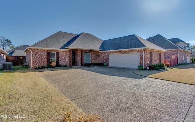 view of front of home with cooling unit, a garage, and a front lawn