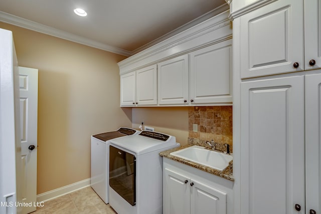 clothes washing area featuring cabinets, crown molding, sink, light tile patterned floors, and separate washer and dryer