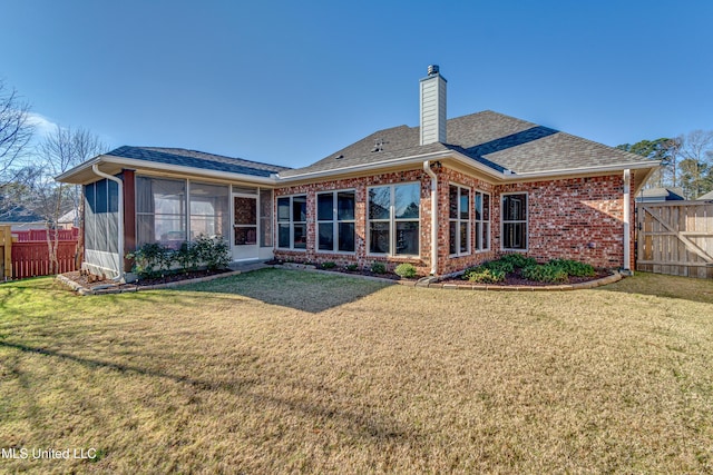 back of property with a sunroom and a lawn