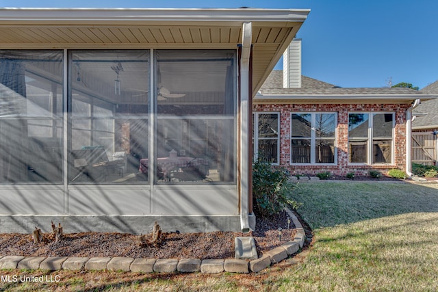 view of home's exterior featuring a sunroom and a yard