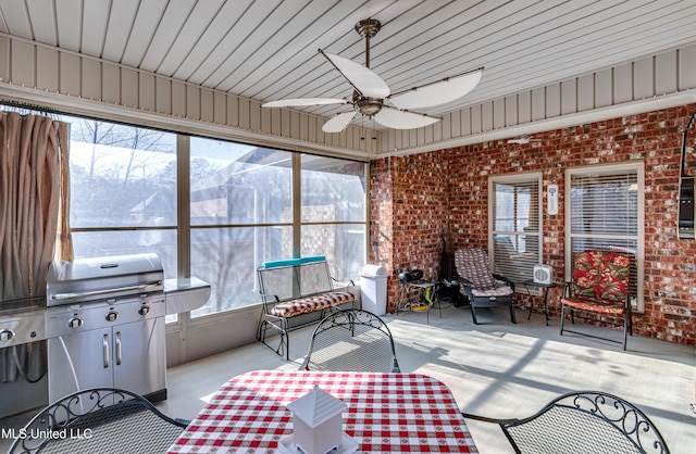 sunroom / solarium with a mountain view and ceiling fan