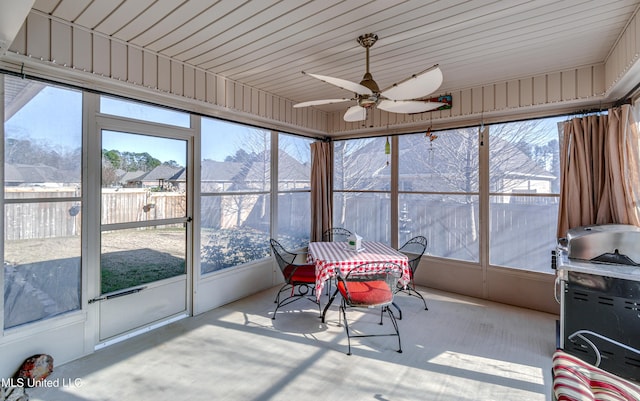 sunroom / solarium featuring a mountain view, ceiling fan, and wood ceiling