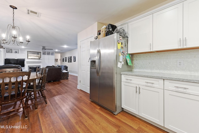 7829 Alawai Ave, Diamondhead, MS 39525 - kitchen with visible vents, stainless steel refrigerator with ice dispenser, wood finished floors, open floor plan, and a notable chandelier