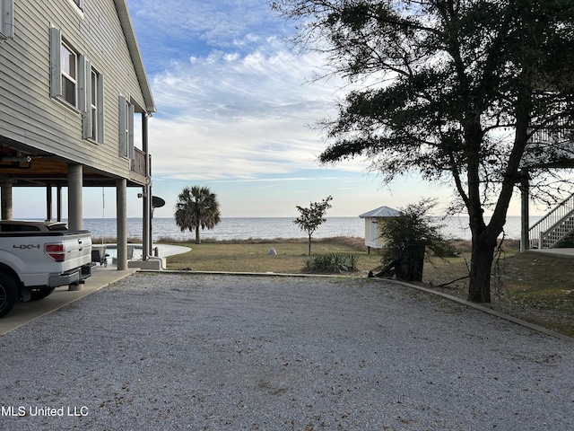 view of yard with a water view and a carport