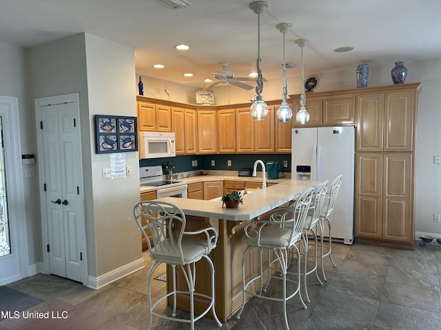 kitchen with white appliances, a center island with sink, visible vents, a breakfast bar, and light countertops