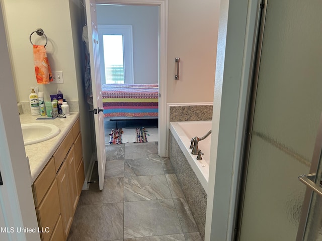 ensuite bathroom with a garden tub, ensuite bath, and vanity