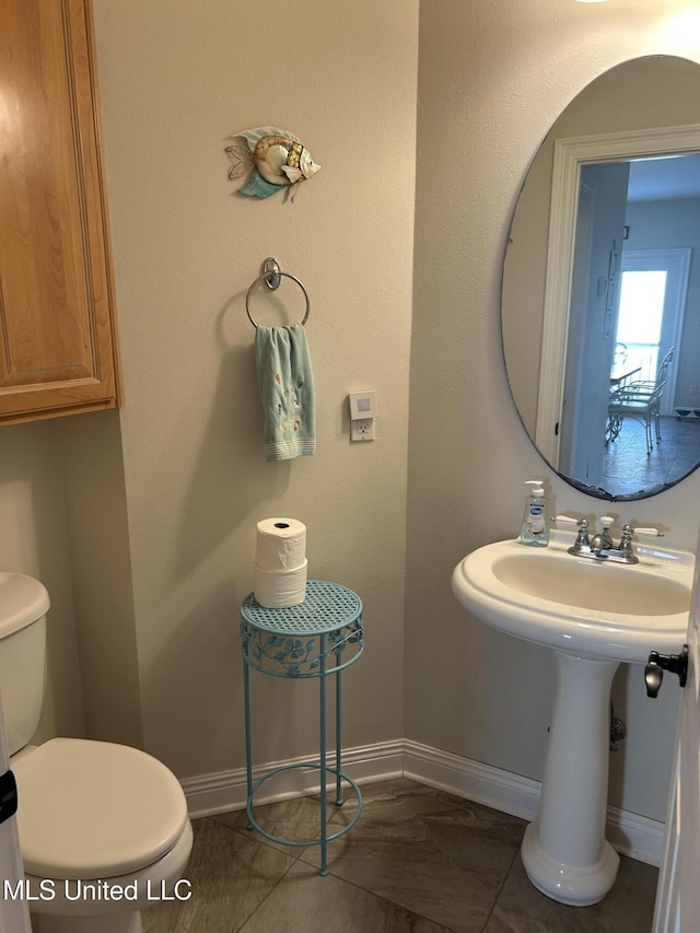 bathroom featuring toilet and baseboards