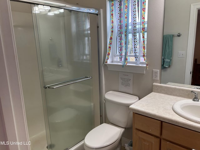 full bath featuring a stall shower, vanity, and toilet