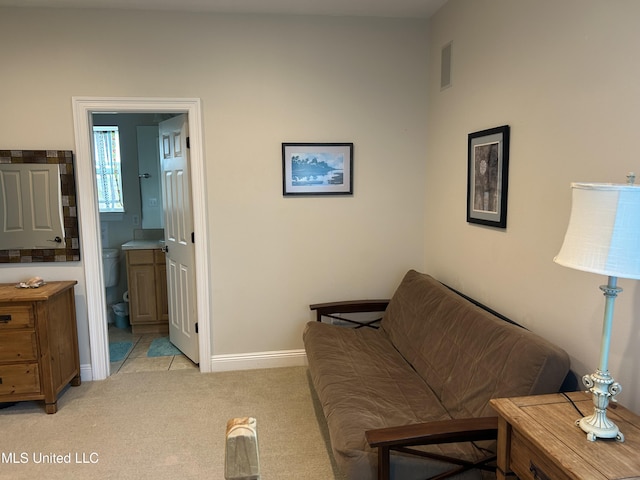 sitting room with baseboards, visible vents, and light colored carpet