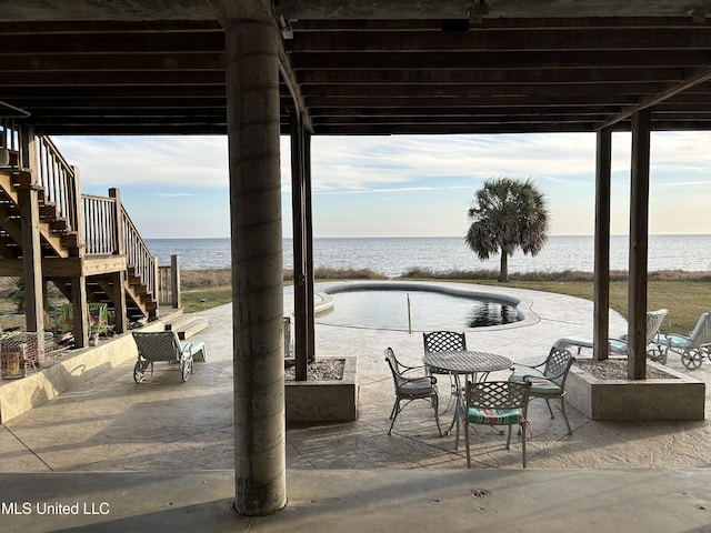 view of patio featuring a water view and stairs