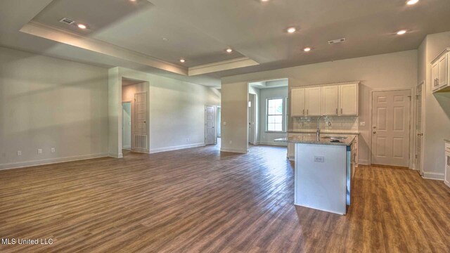 kitchen featuring white cabinetry, a tray ceiling, and dark hardwood / wood-style floors