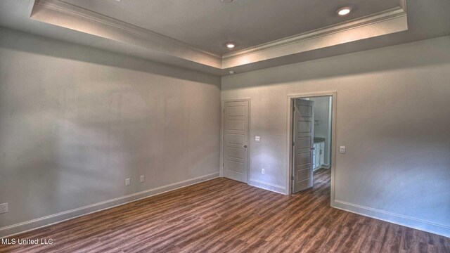 unfurnished room featuring ornamental molding, dark hardwood / wood-style floors, and a raised ceiling