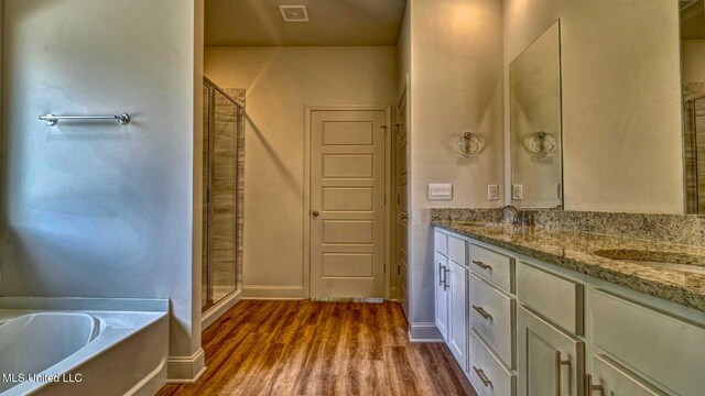 bathroom with vanity, hardwood / wood-style flooring, and plus walk in shower