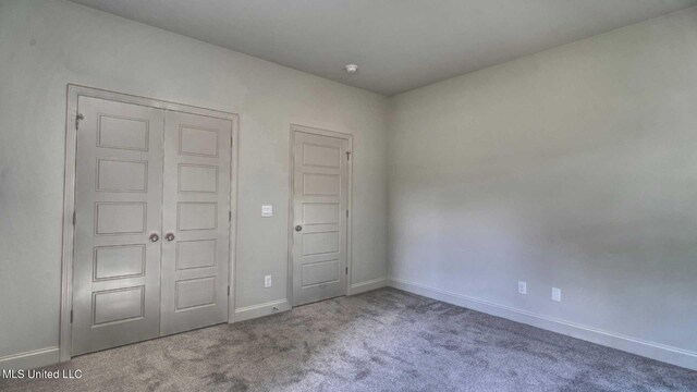 unfurnished bedroom featuring a closet and light carpet