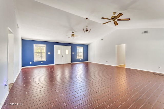 spare room with ceiling fan with notable chandelier and lofted ceiling